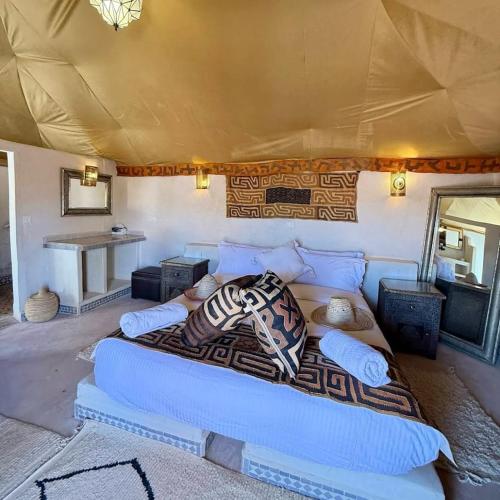 a bedroom with a couch in a tent at Erg Chigaga Luxury Camp in El Gouera