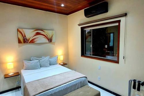 a bedroom with a white bed and a window at Hotel Gran Minas in Vespasiano