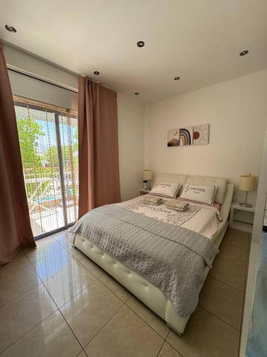 a large bed in a bedroom with a large window at Royal Park Eilat 138 duplex in Eilat