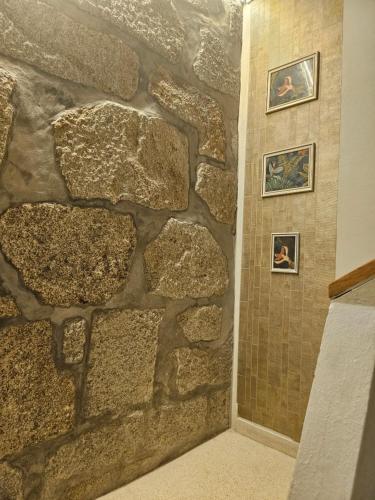 a stone wall in a bathroom with a shower at Muralha da Barca Apartamentos -Fique no centro do Porto junto a ponte D-Luis IRNAL nº13939 Al,5848 Al, 6419 AL-Chamada para a rede móvel nacional in Porto