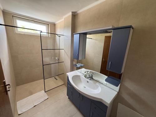 a bathroom with a sink and a shower at Hotel Lux in Mitrovica