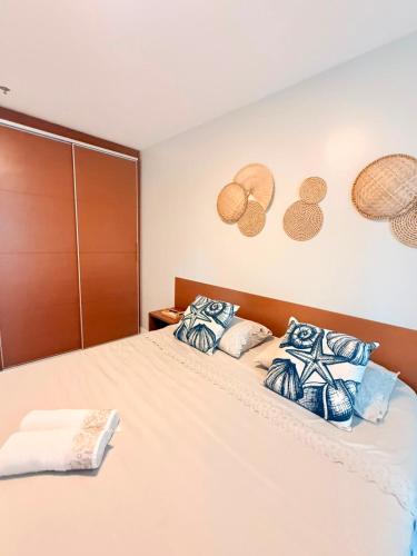 a bedroom with a bed with blue and white pillows at FLAT MANDAI PREMIUM - Cabo Frio in Cabo Frio