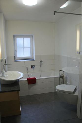 a bathroom with a sink and a tub and a toilet at Villa Hilde in Oy-Mittelberg
