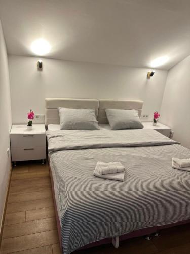a bedroom with a large bed with two night stands at Apartmani Stevanović in Zvornik