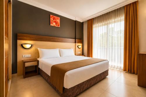 a bedroom with a large bed and a large window at Hawaii Suite Beach Hotel in Alanya