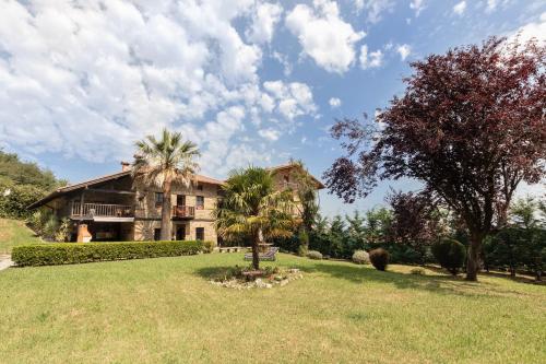 a house with a palm tree in front of a yard at Caserio Urikosolo in Bilbao