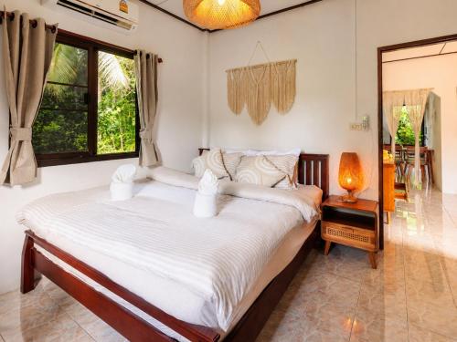 a bedroom with a large bed with white sheets at Amsterdam House - Hin Kong - Double King Bed - 4K SmartTV in Wok Tum