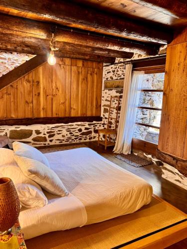 a large bed in a room with wooden walls at Cal David Estamariu in Estamariu