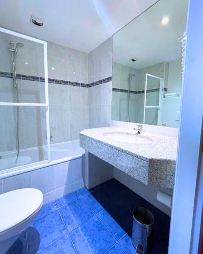a bathroom with a sink and a tub and a toilet at Hôtel Restaurant Chez Henriette in Phalsbourg