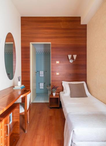 a bedroom with a large bed and a desk at Hotel Gala in Pesaro