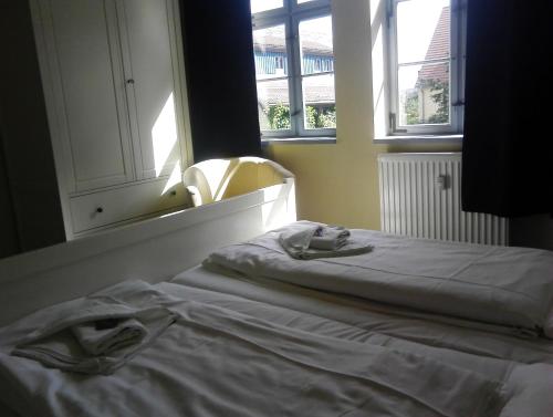 a bed sitting in a room with two windows at Alte Apotheke in Radebeul