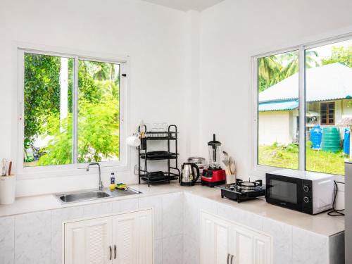 a white kitchen with a sink and two windows at Boho House - 2mn Srithanu - King Bed - 4K SmartTV in Hinkong