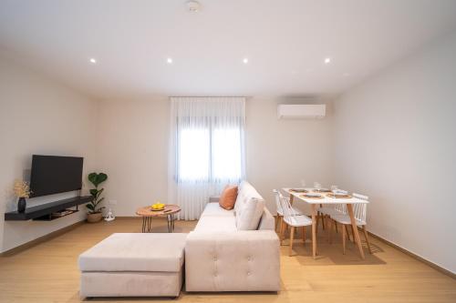 a living room with a white couch and a table at Anemi Residence in Chios