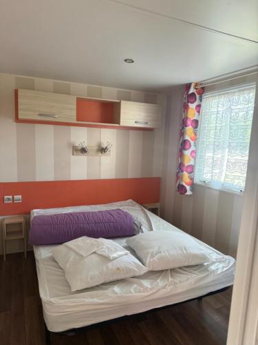 a small bedroom with a bed with at Camping Le Capdeville in Carcans