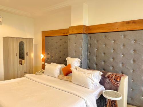 a bedroom with a large bed with white pillows at Appart Hotel Les orchidees in Cotonou