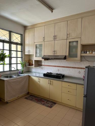 a large kitchen with a sink and a refrigerator at Casa Sara in Nilai