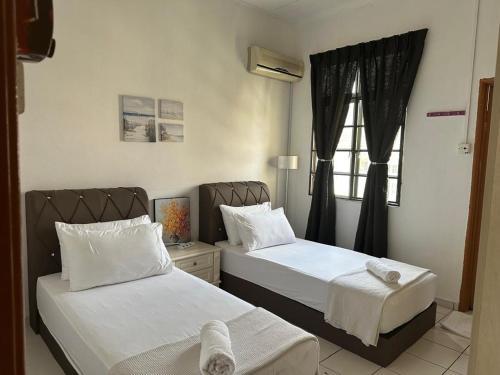 a bedroom with two beds and a window at Casa Sara in Nilai