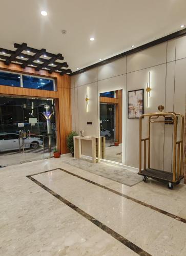 a large lobby with a table and glass doors at المها إن للشقق المخدومة in Hail