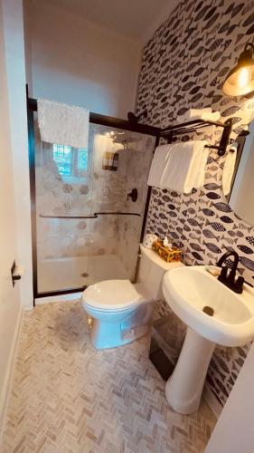 a bathroom with a toilet and a sink at The Independent Inn in Key West