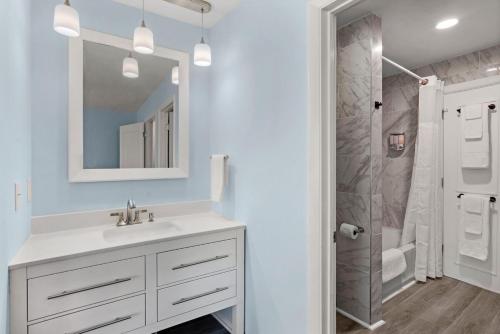 a white bathroom with a sink and a shower at Tranquil Condo with Pond View in Charleston