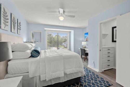 a bedroom with a bed and a desk and a window at Tranquil Condo with Pond View in Charleston