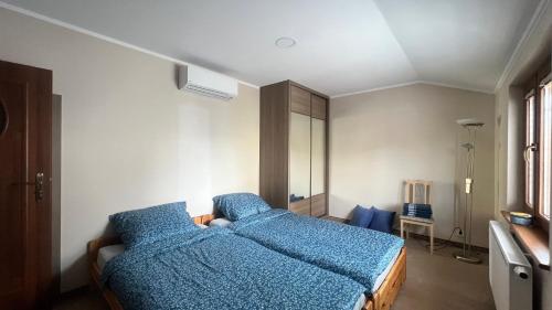 a bedroom with a bed with blue sheets on it at Przystań przy Krzywej in Dziwnów