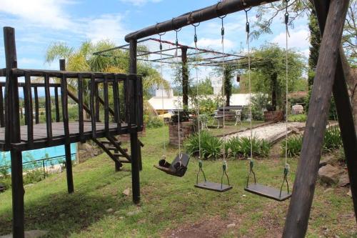 a swing set with three swings in a yard at cabañas aleli in Embalse