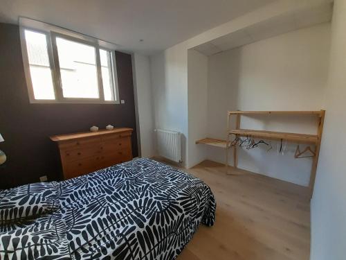 a bedroom with a black and white bed and a window at loft with a garage feel in Périers