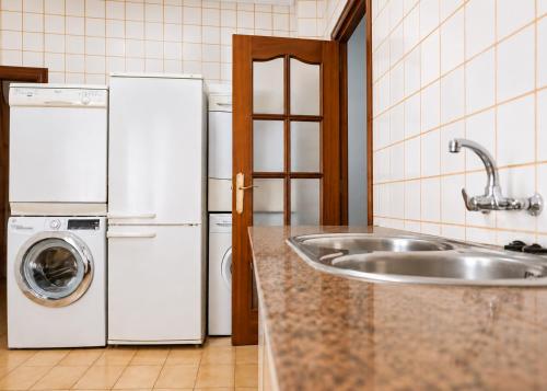 a kitchen with a sink and two white refrigerators at Casa Arcadia Centro de Andalucía in Encinas Reales
