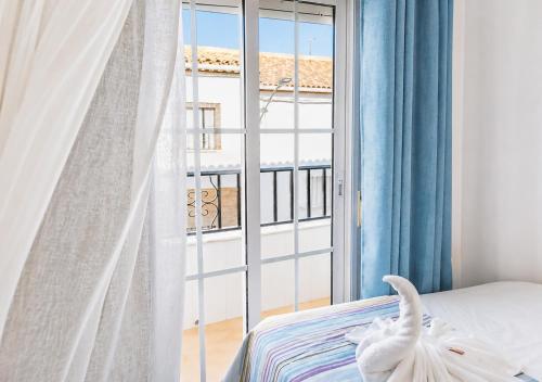 a bedroom with a bed and a large window at Casa Arcadia Centro de Andalucía in Encinas Reales