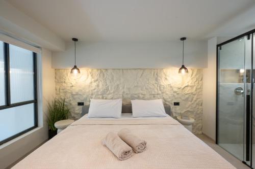 a bedroom with a large bed with two towels on it at NOMA Suites in Kalamata