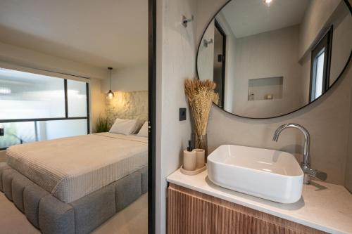a bathroom with a bed and a sink and a mirror at NOMA Suites in Kalamata