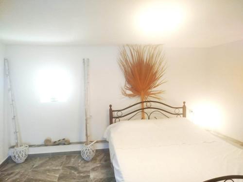 a bedroom with a white bed and a plant on the wall at Volcanic Stone Cottage Sea View & Yard in Kipséli
