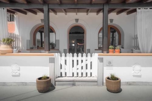 a white fence with potted plants in front of a building at Beachfront House Pythagorion in Pythagoreio
