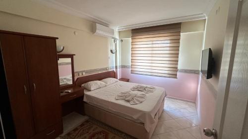 a small bedroom with a bed and a window at Yağmur Apart Otel in Didim