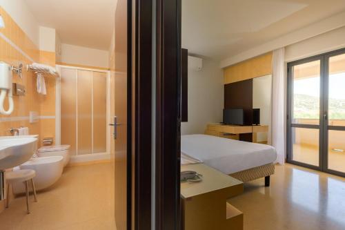 ein Hotelzimmer mit Bett und Badezimmer in der Unterkunft Rada Siri in Montepaone