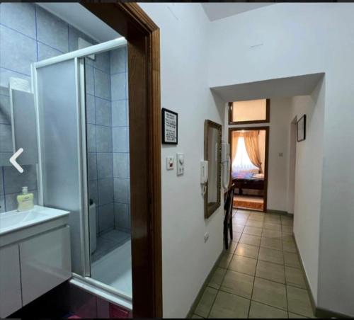 a bathroom with a shower and a sink and a mirror at Vila Milka in Lepterija