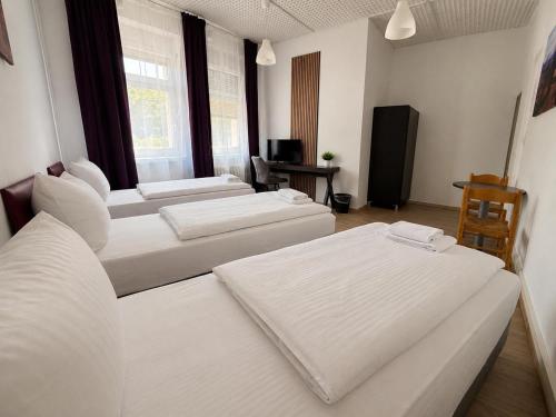 a room with three beds and a television at Pension Reiter in Berlin