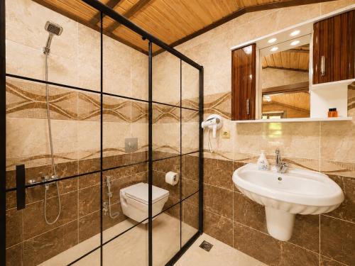 a bathroom with a toilet and a sink at Şimo Suite Otel in Uzungöl