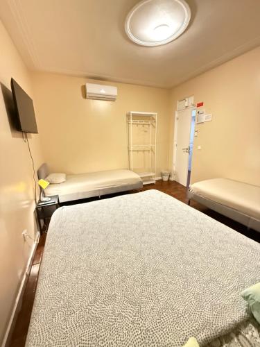 a hospital room with two beds and a tv at Lisboa Parque Guest House in Lisbon