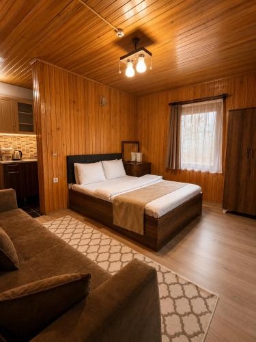 a bedroom with a bed and a couch in a room at Han PANSİYON in Çaykara