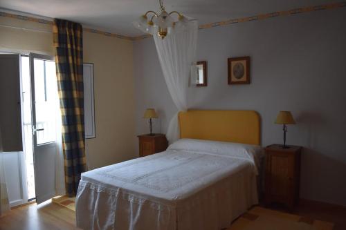 a bedroom with a bed and two lamps and a window at Casa Nicolás in Portomarin