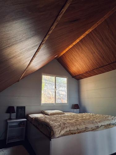 a bed in a room with a wooden ceiling at The Margallia in Islamabad