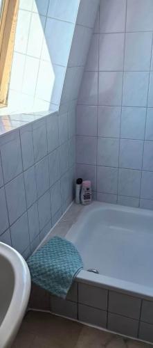 a white bathroom with a tub and a sink at Pension Markt Neustrelitz in Neustrelitz