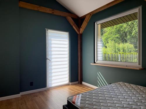 una camera da letto con una finestra e un letto in una stanza di Chill and Grill - Modlin Airport Apartamenty na wynajem a Wola Smolana