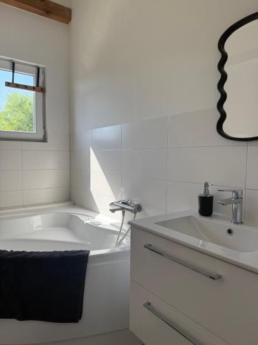 un bagno bianco con vasca e lavandino di Chill and Grill - Modlin Airport Apartamenty na wynajem a Wola Smolana