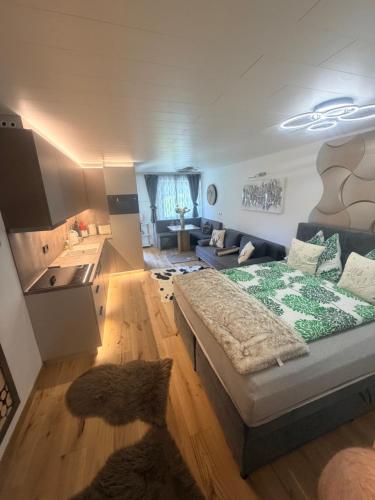 a living room with a large bed and a kitchen at Emerald Alpine Apartment Seefeld in Seefeld in Tirol