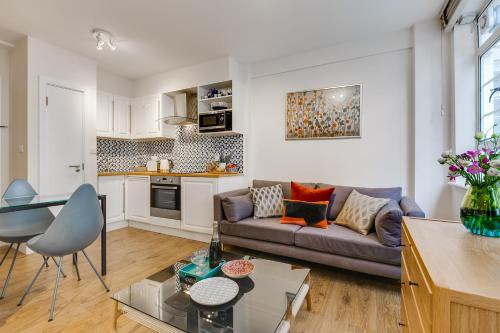 a living room with a couch and a table at Nell Gwynn Chelsea Accommodation in London
