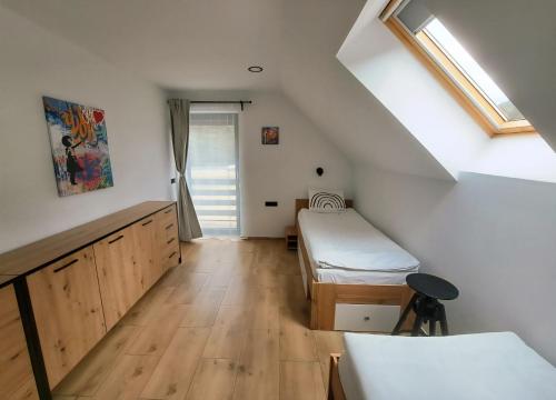 a attic room with two beds and a window at Riverside Apartma 1, Kranjska Gora in Kranjska Gora