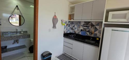 a kitchen with white cabinets and a sink at Águas de Canto Grande in Bombinhas